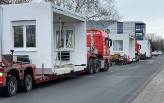 Modulgebäude aus Betonfertigteilen auf dem Weg zu ihrem Aufstellungsort